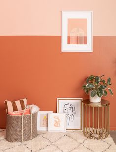 a living room with an orange and pink color scheme on the wall next to two pictures