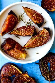 roasted eggplant on a white plate with rosemary sprigs and seasoning