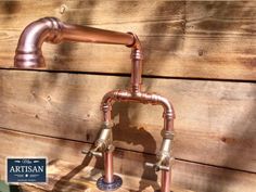 an old fashioned faucet made out of copper pipes and fittings on a wooden wall