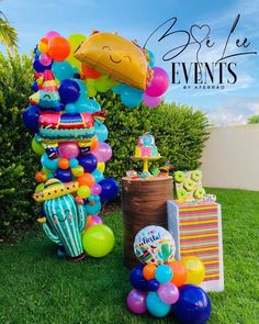 an assortment of balloons and decorations on the lawn