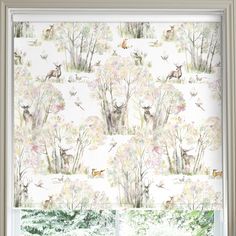 a window with deer and trees printed on the blind in front of it, next to a window sill