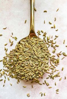 a spoon filled with seeds on top of a table