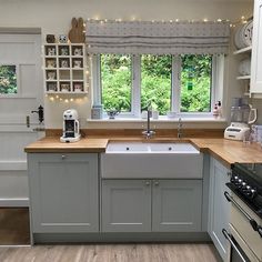 a kitchen with an oven, dishwasher, sink and window in the background