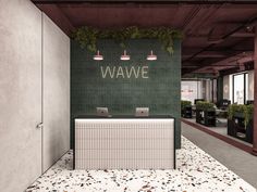 an office with green and white tiles on the wall next to a reception desk that says wave