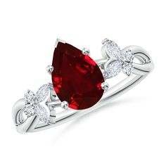 an oval shaped ruby and diamond ring with two pear shaped diamonds on the band, set in white gold