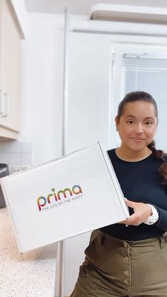 a woman holding up a box with the word prima on it