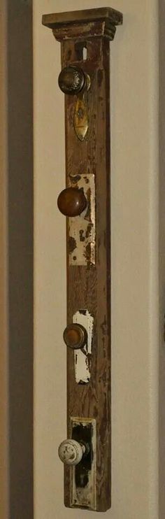 an old wooden clock hanging on the wall with knobs and plates attached to it