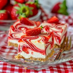 a slice of strawberry swirl cheesecake on a glass plate with strawberries in the background