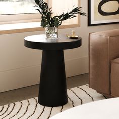 a living room with a couch, chair and vase filled with flowers on the table