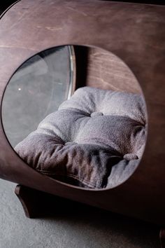 a round wooden table with a cushion on it