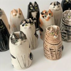 a group of ceramic cats sitting next to each other