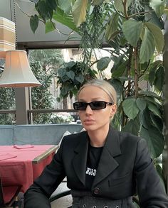 a mannequin wearing sunglasses sitting at a table