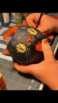 someone is painting a black cat mask on the table