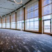 an empty room with large windows and carpet