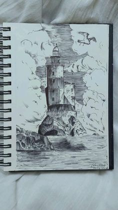 a notebook with a drawing of a lighthouse on it