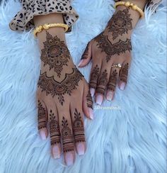 two hands with henna tattoos on them