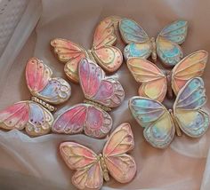 there are many different colored butterflies on the table together, one is pink and one is blue