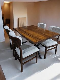 a wooden table with white chairs around it