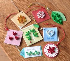 some cards are sitting on a table with string attached to them and paper flowers in the middle