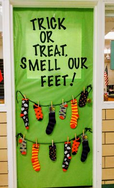 a green door decorated with socks and saying trick or treat smell our feet