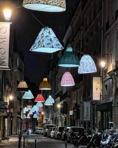 many lamps are hanging from the ceiling in an alley way