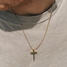 a man wearing a necklace with a cross on it