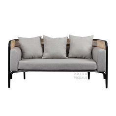 a gray couch with four pillows on it's back and two sides, one is facing