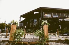 a large building with lots of plants on the front and side of it, along with a wooden deck