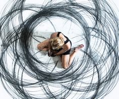 a woman in a black swimsuit sitting on top of a surfboard surrounded by hair