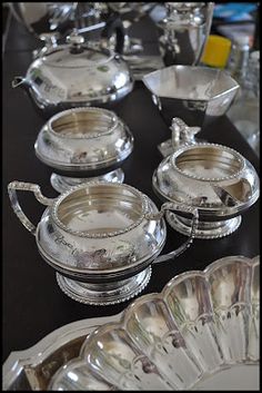 a table topped with lots of silver dishes