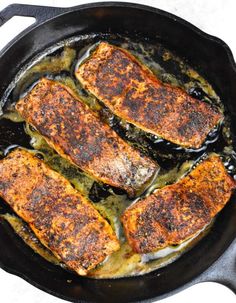 three pieces of fish cooking in a skillet