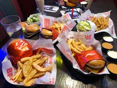 several baskets filled with different types of food sitting on top of a table next to drinks and condiments