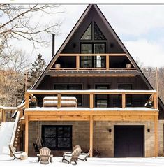 a large house in the snow with two lawn chairs and one chair on the porch