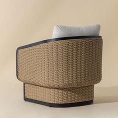 a wicker chair with a white pillow on it's back and black frame