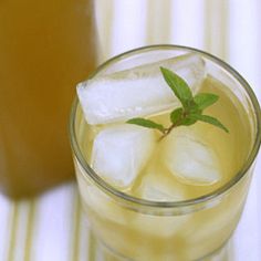 a glass filled with ice and mint on top of a table