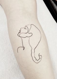 a person with a tattoo on their leg that has a line drawing of a woman's face