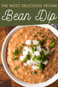 the most delicious vegan bean dip in a bowl with onions and cilantro