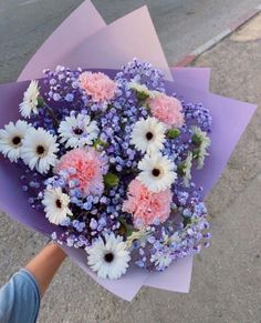 a person holding a bouquet of flowers on the street