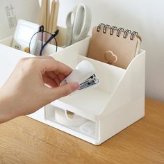 a person's hand is holding a pen and paper holder