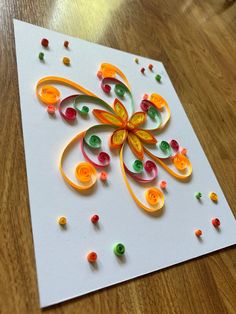 an intricately designed greeting card on a wooden table with confetti sprinkles