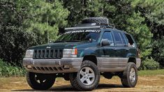 a green jeep parked on top of a dirt road