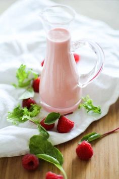 raspberry yogurt in a glass pitcher and fresh berries on the table