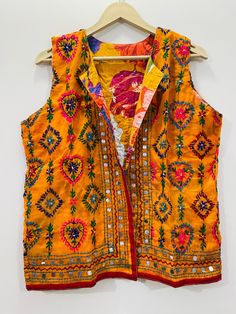 Fulkari open vest is made from a soft traditional indian phulkari handmade scarf. the scarves are used for festive occasions like weddings. the phulkari scarf is hand embroidered and embellished by indian artisan. vest has long wide vest coat. the vest jacket has an open front, and the length is normal jacket. indian chanderi silk phulkari hand work boho fashion kimono robe jacket. indian embroidered boho style beach wear body cover up. reversible vest jackets/coat you can wear this one in both side one side is phulkari embroidered and other side is cotton printed. *buy it for the holidays! looks fabulous over a long silk tank dress or palazzo pants. or wear it with to install jeans and boots. measurements: colour: as per the picture approx length : 23 inch / 60 cm bust approx : 40 inch / Bohemian Outerwear For Festive Wedding, Multicolor Nehru Jacket For Navratri, Bohemian Fitted Nehru Jacket For Festivals, Fitted Bohemian Nehru Jacket For Festivals, Bohemian Nehru Jacket With Zari Work For Festive Season, Festive Bohemian Nehru Jacket With Zari Work, Traditional Multicolor Festive Vest, Festive Embroidered Vest For Festivals, Traditional Multicolor Embroidered Vest For Festivals