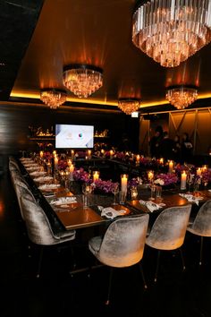 a large dining room with chandeliers and long tables