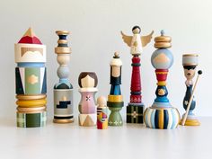 a group of wooden toys sitting on top of a white table next to each other