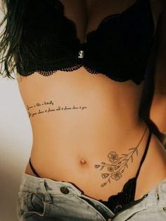 a woman's stomach with tattoos on it and words written in cursive writing