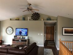 a living room filled with furniture and a flat screen tv on top of a wooden dresser