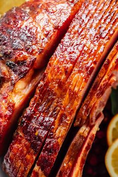 a close up of meat on a plate with oranges and cranberry sauce