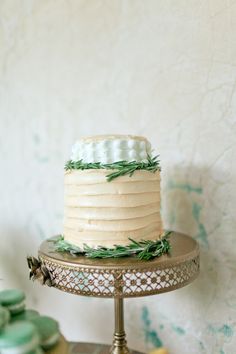 a white cake sitting on top of a metal stand