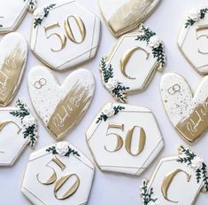 decorated cookies with the number 50 and wedding date are arranged on a white tablecloth